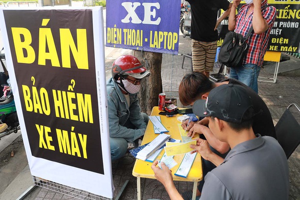 Ùn ùn mua bảo hiểm xe máy để phòng hờ cảnh sát giao thông - Ảnh 1. Ùn ùn mua bảo hiểm xe máy để phòng hờ cảnh sát giao thông - Ảnh 1.