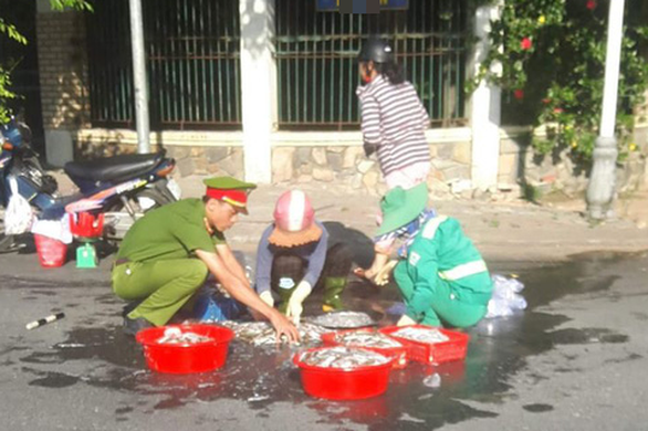 Dễ thương anh công an, chị lao công giúp dân lượm hết mớ cá đổ trên đường - Ảnh 1. Dễ thương anh công an, chị lao công giúp dân lượm hết mớ cá đổ trên đường - Ảnh 1.