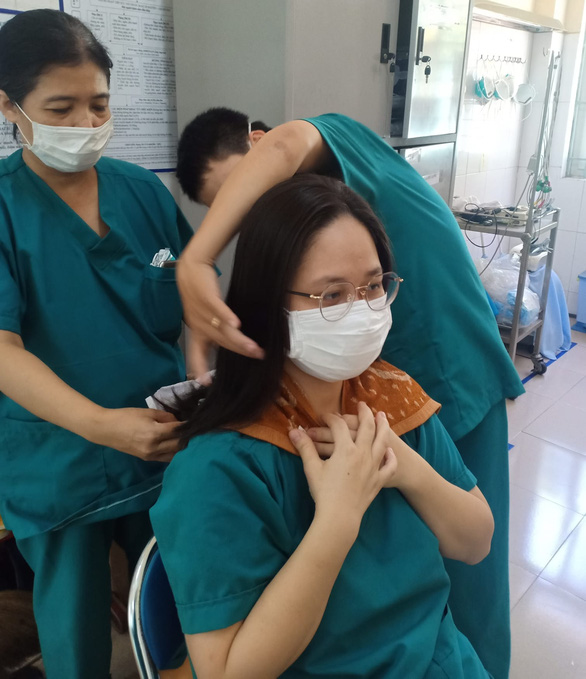 Nghẹn lòng sau bức ảnh các nữ bác sĩ cắt tóc để lên tuyến đầu ở Đà Nẵng - Ảnh 2.