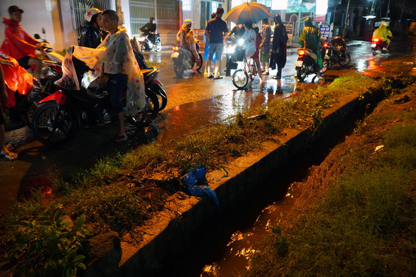 The camera recorded a woman walking through a ditch in the street, unable to save time - Photo 1.