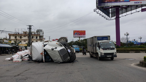 Xe container ôm cua lật ngang giữa bùng binh, tài xế thoát chết - Ảnh 1.