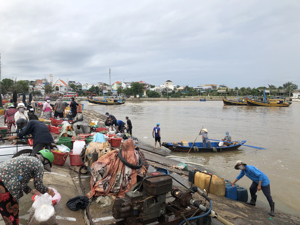 Ngư dân tranh thủ trước giờ cảng cá Phan Thiết tạm dừng hoạt động - Ảnh 1.