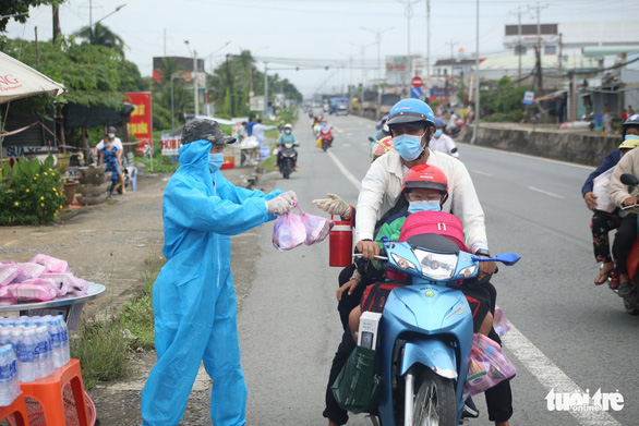 Hàng ngàn bà con miền Tây về quê, người dân đứng dọc đường tặng cơm nước - Ảnh 3.