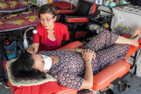 Vượt nghịch cảnh mất tay, cô thợ cắt tóc Việt Nam lên báo Tây - Ảnh 2.
