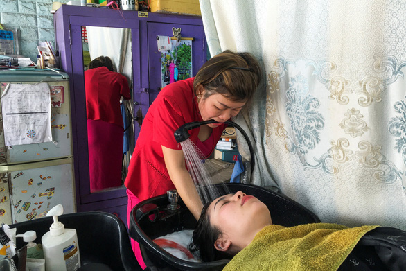 Vượt nghịch cảnh mất tay, cô thợ cắt tóc Việt Nam lên báo Tây - Ảnh 3.
