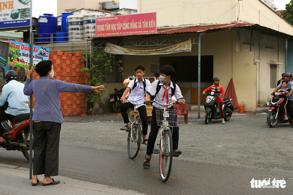 Bà ngoại Hai cầm bảng canh xe cho học trò qua đường an toàn - Ảnh 2.