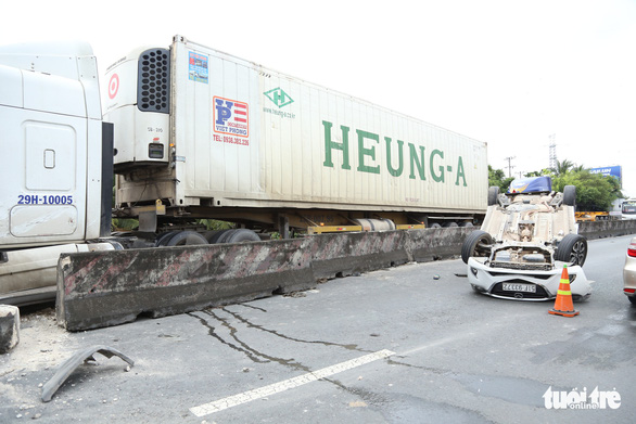 Sau va chạm, ôtô 4 chỗ bay qua dải phân cách lật ngửa trên quốc lộ - Ảnh 1.