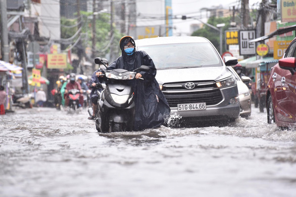 TP.HCM: Mưa như trút giờ cao điểm, dân bì bõm dắt xe chết máy qua điểm ngập - Ảnh 3.