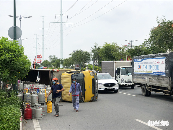 Lật xe chở gas, hàng chục bình gas văng xuống đường Phạm Văn Đồng - Ảnh 3.