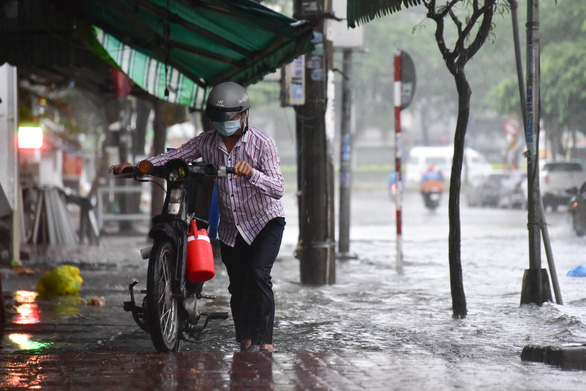 TP.HCM mưa trắng trời, nhân viên trực chốt đẩy xe dân qua chỗ ngập - Ảnh 4.