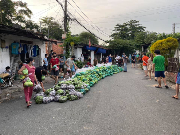 TP.HCM: Công an đội mưa, vác gạo, rau củ quả... ‘tiếp tế’ người dân khu trọ, phong tỏa - Ảnh 2.