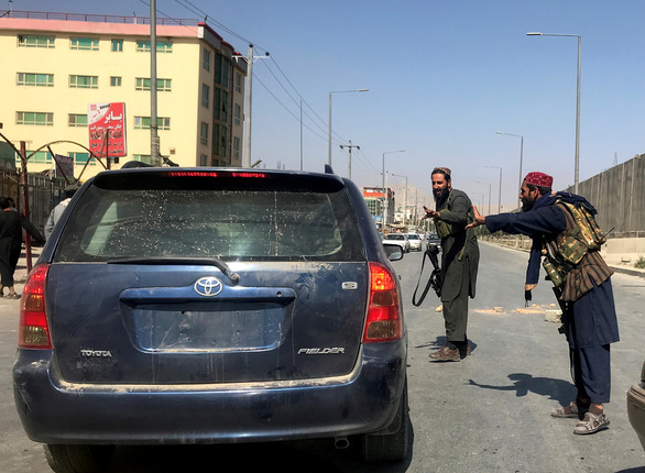 Taliban thiết lập trật tự quanh sân bay Kabul, hàng dài người xếp hàng chờ đợi - Ảnh 1.