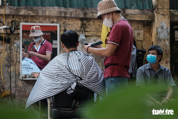Tiệm cắt tóc vỉa hè, salon tóc đông kín khách ngày đầu mở lại - Ảnh 6.
