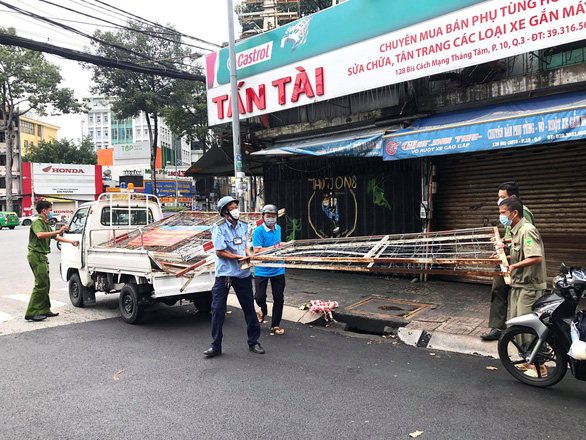 Các chốt hàng rào sắt, dây kẽm gai, tôn... ở TP.HCM đang được tháo dỡ - Ảnh 1.