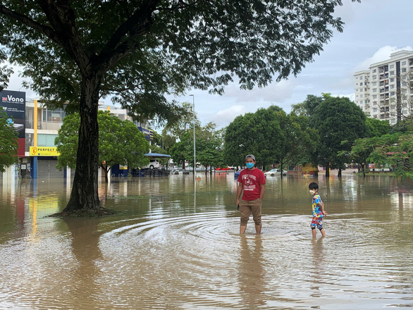 Lũ lụt chết người, nhiều người Malaysia vẫn lội nước quay TikTok - Ảnh 1.