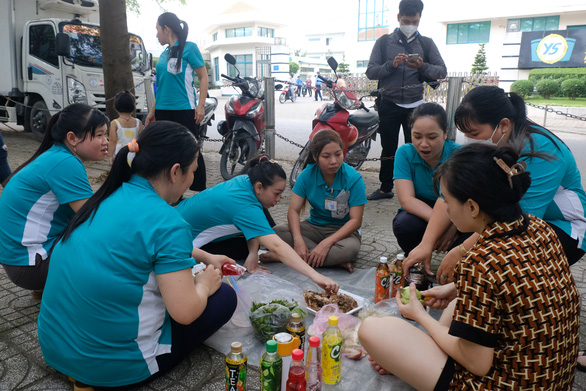 Công nhân ‘hùn’ tiền ăn chia tay ngay trên vỉa hè khi công ty cho nghỉ việc hàng loạt - Ảnh 1.