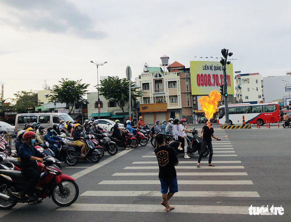 Người biểu diễn ngậm dầu phun lửa tràn ra các ngã tư đường, nguy cơ mất an toàn - Ảnh 1.