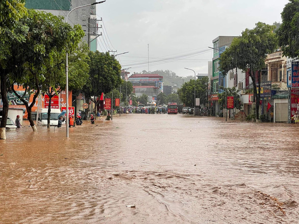 Sau cơn mưa lớn, cảnh sát Sơn La bì bõm giúp dân đẩy xe bị ngập - Ảnh 1.
