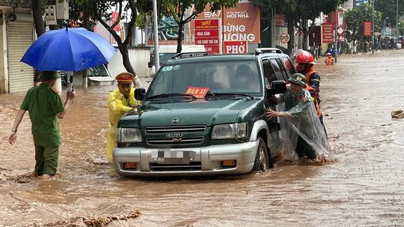Sau cơn mưa lớn, cảnh sát Sơn La bì bõm giúp dân đẩy xe bị ngập - Ảnh 2.