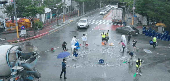Người dân Hàn Quốc đội mưa giúp tài xế chở bia gặp nạn đổ tung tóe - Ảnh 3.