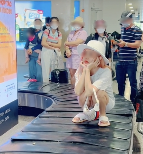 Có thể cấm bay cô gái ngồi trên băng chuyền hành lý quay clip đăng TikTok - Ảnh 1.