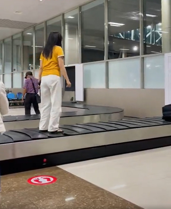 Cô gái mặc áo vàng quần trắng sống ảo trên băng chuyền hành lý - Ảnh 1. Cô gái mặc áo vàng quần trắng sống ảo trên băng chuyền hành lý - Ảnh 1.