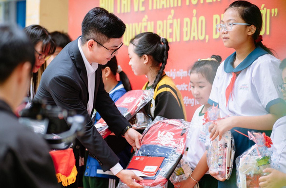 Ông Nguyễn Thiên Anh - quản lý trung tâm Anh văn Hội Việt Mỹ VUS tỉnh Vĩnh Long - trao học bổng và nhiều phần quà cho các em học sinh