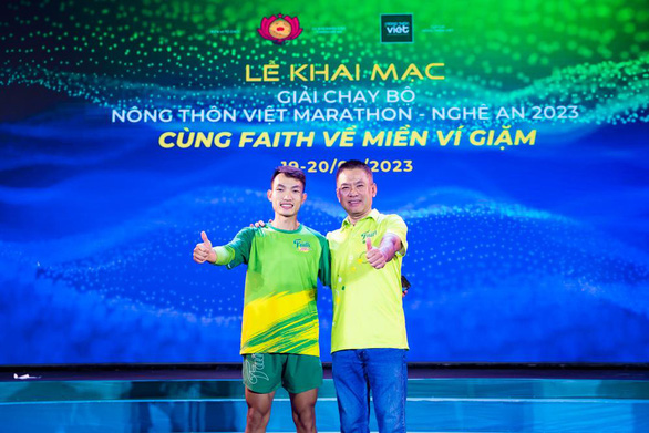 Vận động viên Hoàng Nguyên Thanh - huy chương vàng SEA Games 31 - cùng đại diện nhà tài trợ tại lễ khai mạc giải chạy diễn ra vào tối 19-8.