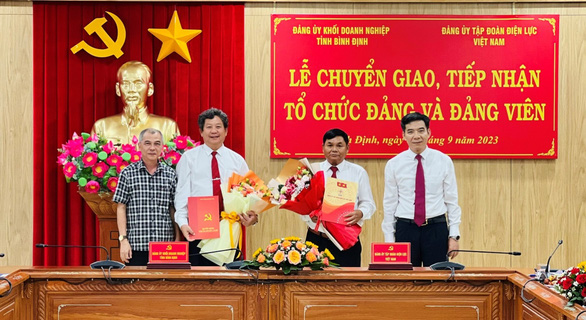 Ông Phạm Vĩnh Thái - tỉnh ủy viên, phó trưởng ban thường trực Ban Tổ chức Tỉnh ủy Bình Định và ông Nguyễn Hữu Tuấn - phó bí thư thường trực Đảng ủy EVN trao quyết định, biên bản chuyển giao, tiếp nhận Đảng bộ cơ sở AKKN - Ảnh: Thu Hoài