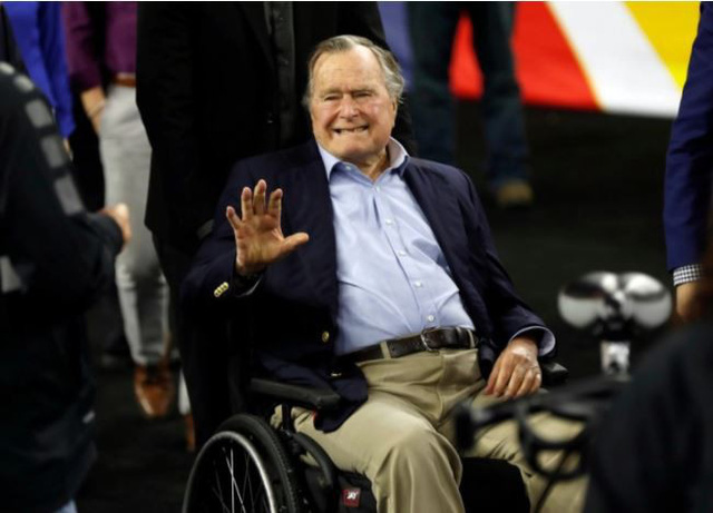 Cựu tổng thống Bush ngồi xe lăn. Ảnh: Reuters