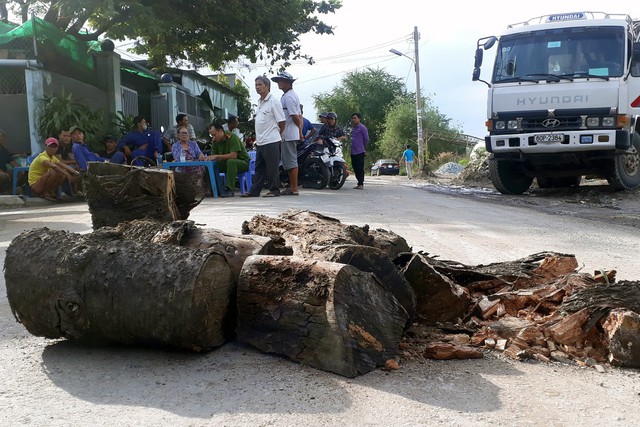 Dân mang gỗ, chậu bông chắn đường ngăn xe tải - Ảnh 1.