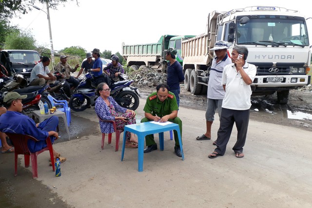 Dân mang gỗ, chậu bông chắn đường ngăn xe tải - Ảnh 4.