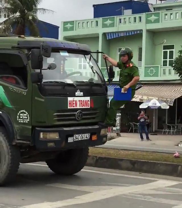 Cảnh sát đu người lên đầu xe tải buộc tài xế dừng xe - Ảnh 2.