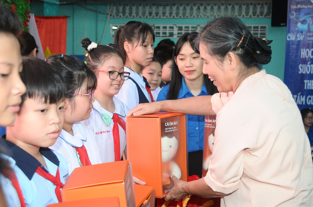 Cô Nguyễn Thị Thanh Hòa (Chủ tịch Hội Bảo vệ quyền trẻ em Việt Nam) trao quà và học bổng cho các bạn học sinh. - Ảnh: TÚ ANH
