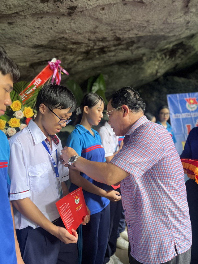 Thầy Nguyễn Hữu Trí (Hiệu trưởng nhà trường) đeo huy hiệu Đoàn cho tân đoàn viên. - Ảnh: NVCC