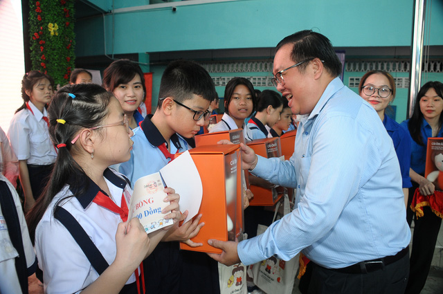 Thầy Phạm Đăng Khoa (Trưởng phòng Giáo dục và Đào tạo quận 3) trao quà và học bổng cho các bạn học sinh. - Ảnh: TÚ ANH