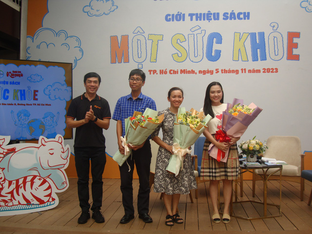 Anh Nguyễn Khắc Cường (phó tổng biên tập báo Tuổi trẻ) trao hoa cho các chuyên gia đến tham dự chương trình. - Ảnh: KHĂN QUÀNG ĐỎ