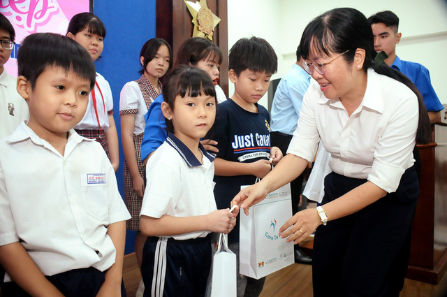 Chị Lê Thị Thu (Phó Giám đốc Nhà thiếu nhi thành phố) trao quà và học bổng cho các bạn nhỏ Ảnh: Nguyễn Hưng