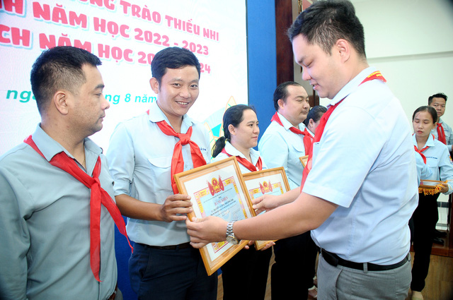 Anh Trương Tấn Nghiệp (Trưởng ban Công nhân lao động Thành đoàn TP.HCM) trao Bằng khen cho anh Trần Bá Minh (Tổng phụ trách Đội trường Nguyễn Thái Bình, quận 12) tại hội nghị - Ảnh: NGUYỄN HƯNG