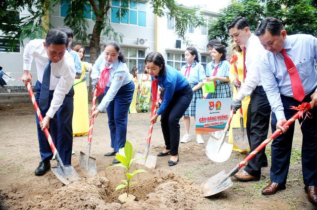 Các đại biểu cùng trồng cây bàng vuông trong khuôn viên trường - Ảnh: NGUYỄN HƯNG