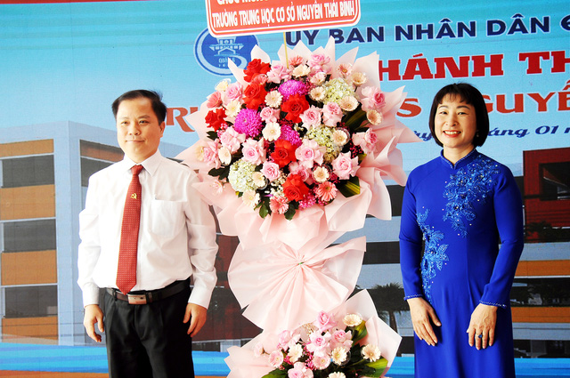 Chú Ma Xuân Việt (bí thư Quận ủy quận 6) tặng hoa chúc mừng cho ban giám hiệu trường. Ảnh: NGUYỄN HƯNG