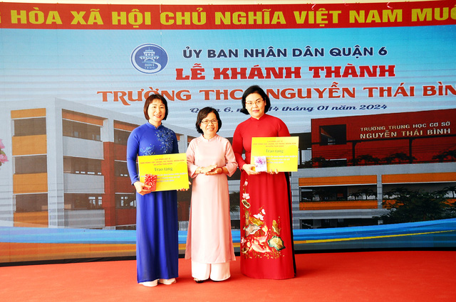 Đại diện gia đình Liệt sĩ Nguyễn Thái Bình trao tặng tư liệu quí cho lãnh đạo quận 6 và nhà trường. Ảnh: NGUYỄN HƯNG