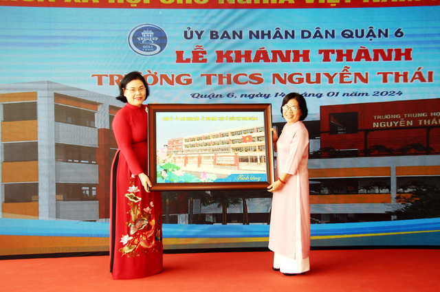 Cô Lê Thị Thanh Thảo (chủ tịch UBND quận 6) trao tặng bức tranh cho gia đình Liệt sĩ Nguyễn Thái Bình. Ảnh: NGUYỄN HƯNG