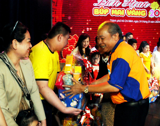 Chú Phạm Ngọc Tuyền (giám đốc Nhà thiếu nhi TP.HCM) trao quà xuân cho các bạn nhỏ tại liên hoan. Ảnh: NGUYỄN HƯNG