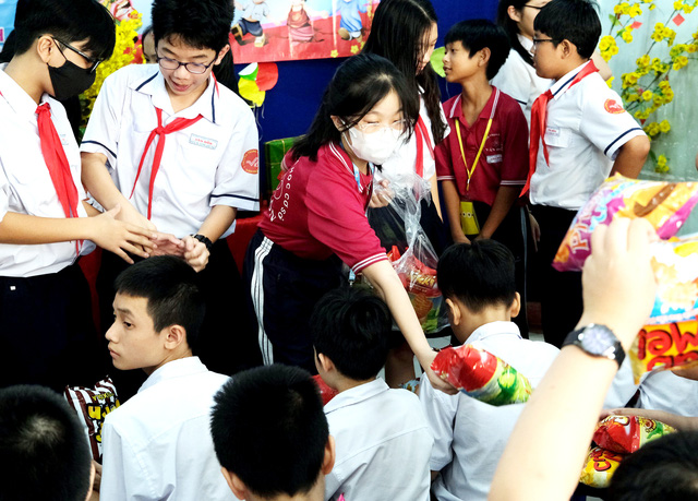 Đội viên Trường THCS Vân Đồn (quận 4) trao quà xuân cho các em nhỏ tại Trường Chuyên biệt 1 tháng 6 (quận 4). Ảnh: NGUYỄN HƯNG
