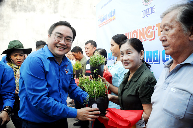 Anh Ngô Minh Hải (phó bí thư thường trực Thành Đoàn TP.HCM) trao tặng cờ nước và chậu hoa tại chung cư Bình Phú (quận 6). Ảnh:NGUYỄN HƯNG