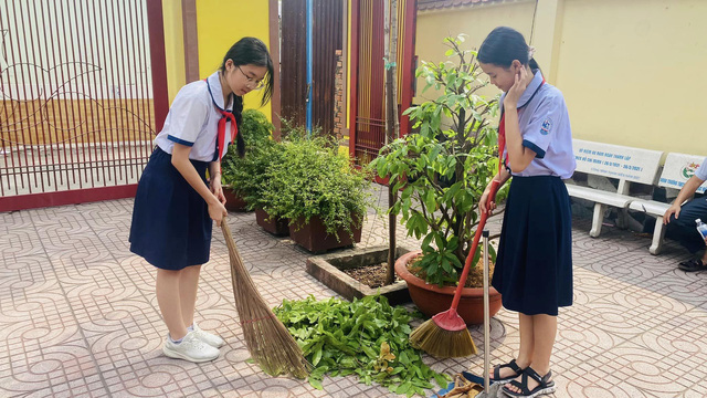 Các bạn đội viên cùng dọn vệ sinh tại di tích Chùa Tường Quang. Ảnh: LÊ VIỆT