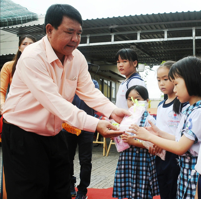 Thầy hiệu trưởng Lê Thanh Hùng trao quà cho các bạn học sinh. Ảnh: NGUYỄN HƯNG