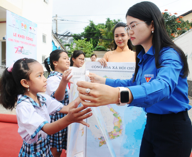 Chị Nguyễn Thị Thanh Hằng (bi thư Huyện Đoàn Nhà Bè) trao bản đồ cho các bạn đội viên. Ảnh: NGUYỄN HƯNG