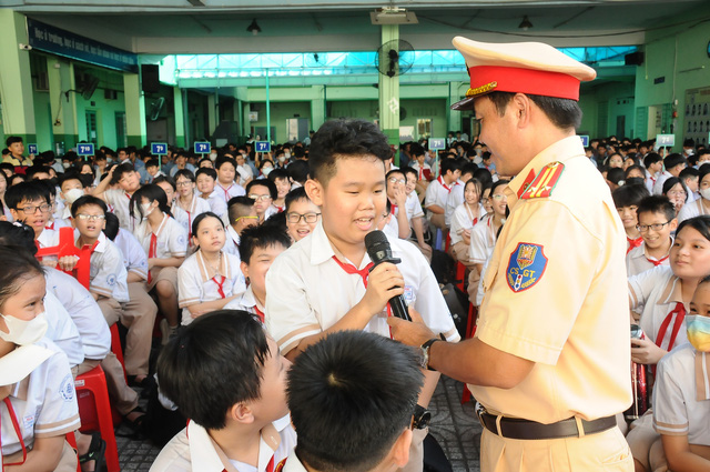 Chú Đinh Minh Vương (cán bộ tuyên truyền Phòng Cảnh sát giao thông, Công an TP HCM) đặt câu hỏi với các bạn học sinh. Ảnh: NGUYỄN HƯNG